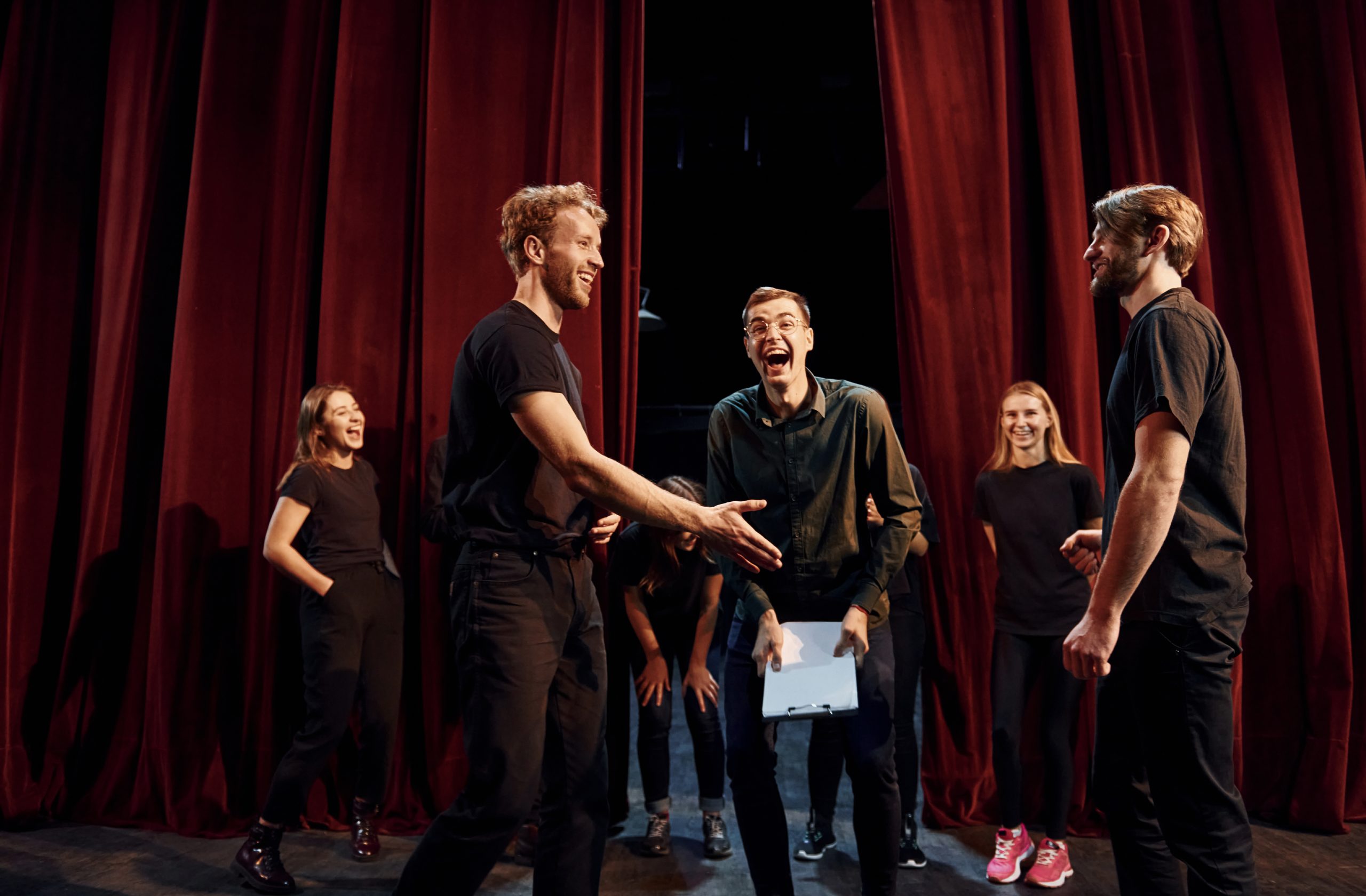 Working together. Group of actors in dark colored clothes on rehearsal in the theater.