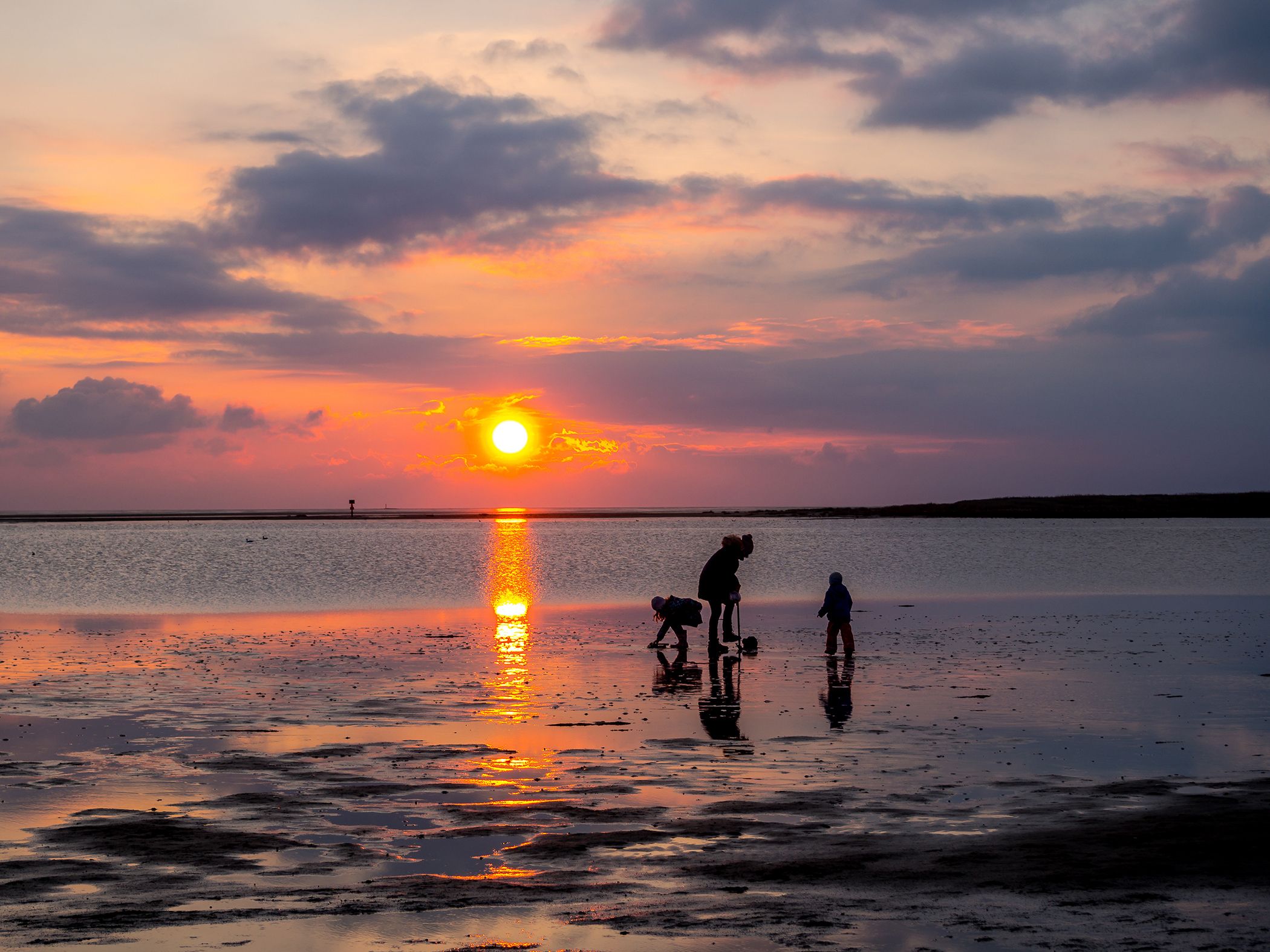 Familie im Watt beim Sonnenuntergang