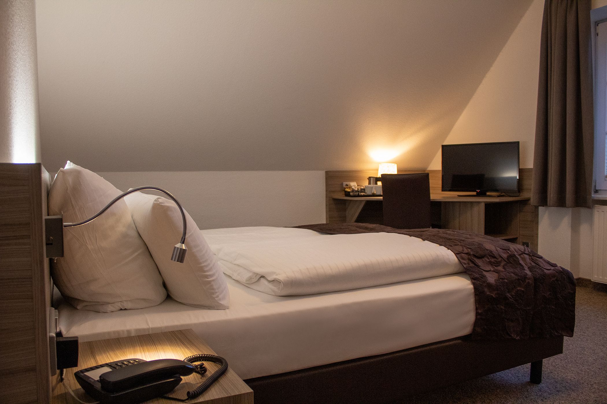 Hotelzimmer mit Bett und Schreibtisch